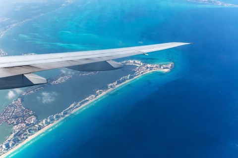 Aerial view through plane window of Caribbean coastline buildings in the hotel zone, Cancun,