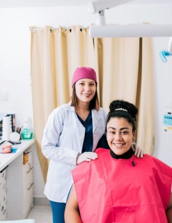 Portrait of dentist with patient smiling at camera in office, Female dentist with satisfied patient