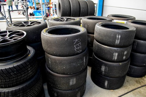 Used tyre pile of used worn tyres Racing tyres middle right Slicks left Rain tyres in front of pit