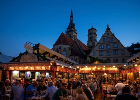 People sitting in wine arbours in the evening, Weindorf Stuttgart, Schillerplatz, collegiate