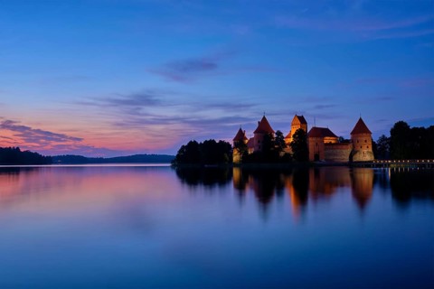 Night view of Trakai Island Castle in lake Galve illuminated in the evening, Lithuania, Europe