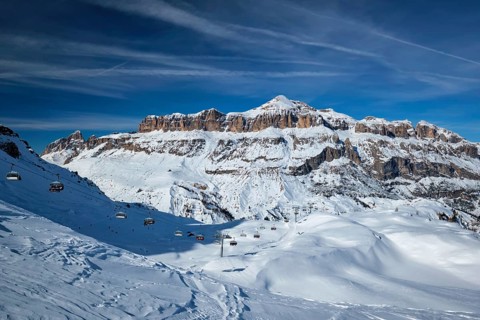 View of a ski resort piste with people skiing in Dolomites in Italy. Ski area Arabba. Arabba,