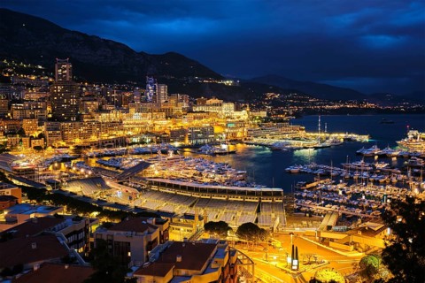 Aerial view of Monaco Monte Carlo harbour and illuminated city skyline in the evening blue hour