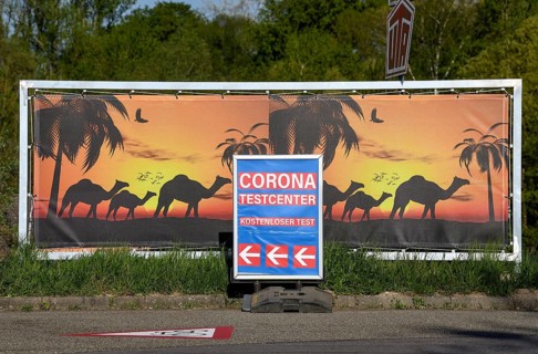 Sign Corona Testcenter in front of camels, border crossing between Gambsheim (France) and