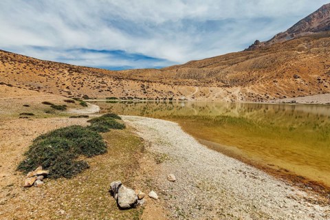 Himalayas mountains refelcting in mountain lake Dhankar Lake. Spiti Valley, Himachal Pradesh,