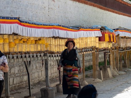 Pilgrims at golden prayer wheels, Xigaze, Tibet, China, Asia