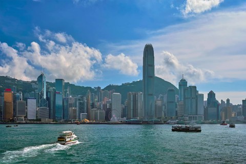 HONG KONG, CHINA, MAY 1, 2018: Boat in Victoria Harbour and Hong Kong skyline cityscape downtown