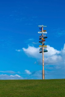 Signpost on dyke to local and world places, Nordstrand peninsula, North Frisia, Schleswig-Holstein,
