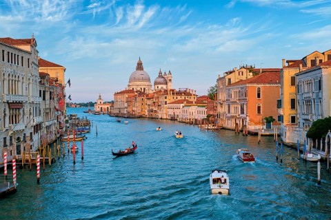 View of Venice Grand Canal with boats and Santa Maria della Salute church on sunset from Ponte