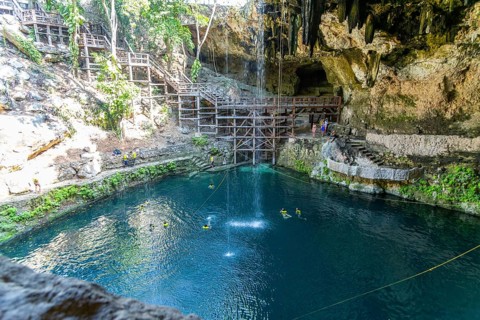 People swimming in Cenote Zaci carboniferous limestone swallow hole pool, Valladolid, Yucatan,