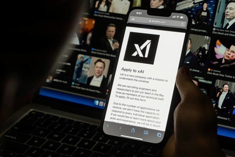 In this photo illustration, A person browses website of xAI, displayed on a mobile phone, Elon Musk