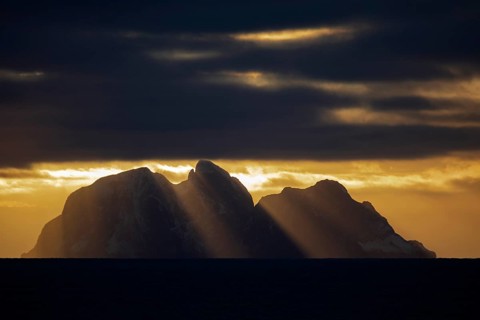 Island Værøy at the southern end of Lofoten under clouds with sunrays