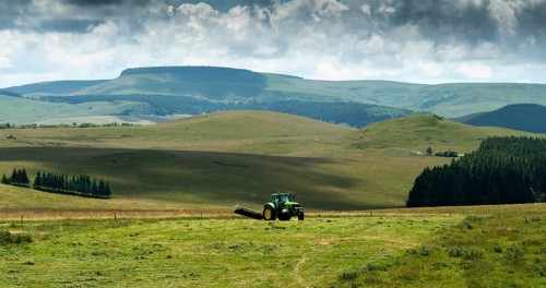 Cezallier plateau. Farmer rowing up hay in the Auvergne volcanoes regional natural park, Puy de
