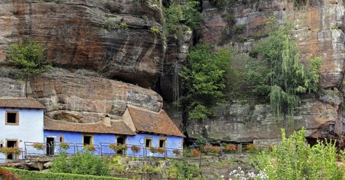 The blue troglodyte houses in rock face at Graufthal, Vosges, Alsace, France, Europe
