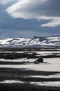 Snow-covered volcanic landscape with volcanic sand and petrified lava, crater of Askja volcano,