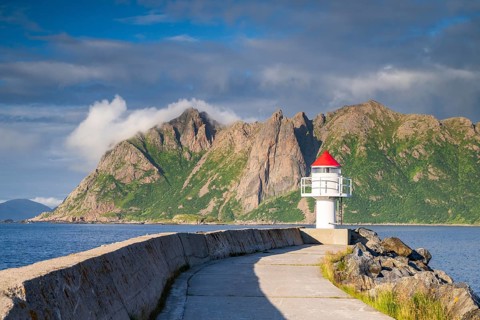 Lighthouse at harbour wall, fishing village Hovden, island Langøya, archipelago Vesterålen, Norway,