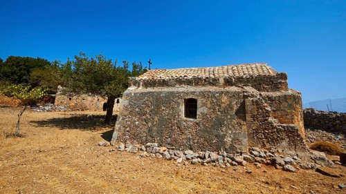 Agios Georgios, chapel, ruins of buildings, stone houses, dry meadow, cloudless blue sky, northeast