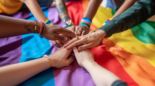 Diverse people hands over rainbow LGBTQ flag showing love, affection and unity, AI generated