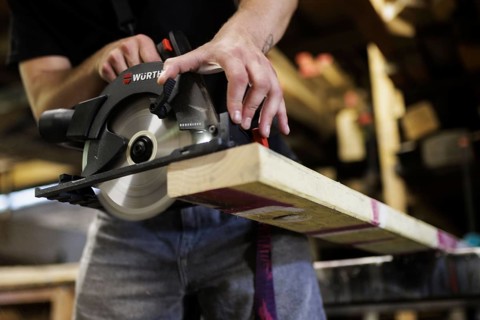 A man cuts wood with a hand-held circular saw. Berlin, 14.08.2024