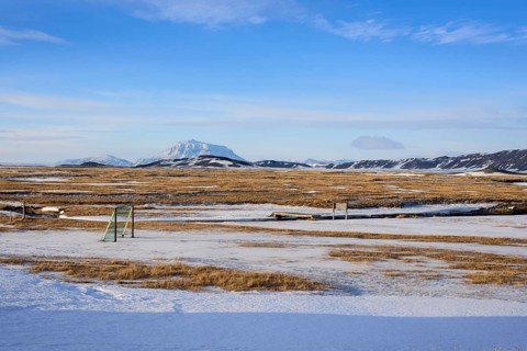 View over snow-covered football playground towards Mt. Herdubreid, winter, farm Mödrudalur, located
