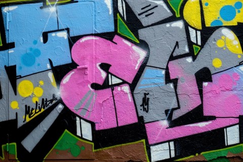 Abstract graffiti art in vibrant colours with dynamic shapes on a rough wall, Landau,