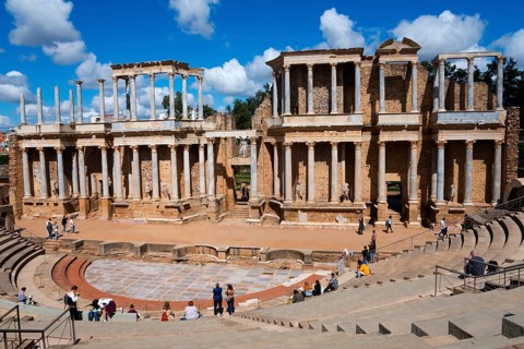 Ancient Roman theatre with stone ruins in the open air, occupied by a few visitors, Teatro Romano