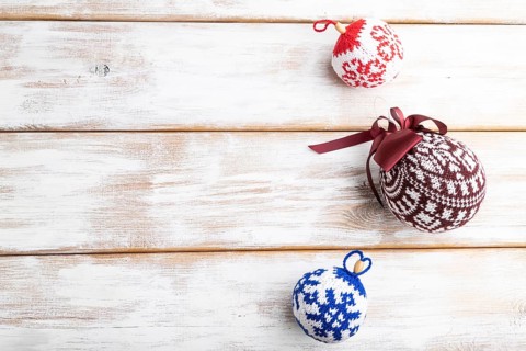 Christmas or New Year composition. Decorations, knitted balls, on a white wooden background. Top