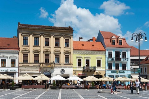 Lively city market square with street cafés and strolling passers-by, town houses on the market