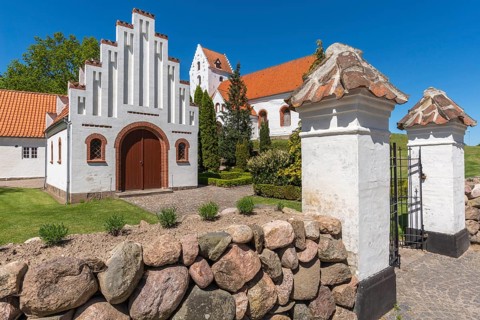 Lindelse Kirke, typical Danish church from 1830, whitewashed, red tiled roof, hill, entrance gate,