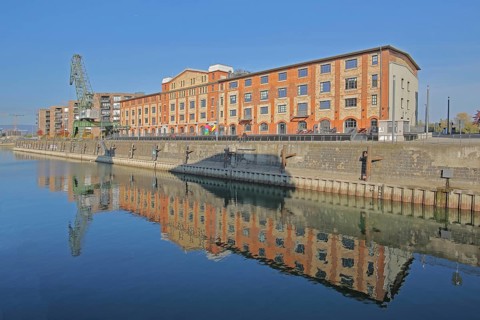 Old wine warehouse with harbour crane, quay and reflection, quay wall, harbour, gantry crane,