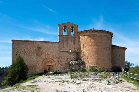 Lonely medieval church with stone walls and bell tower under a clear blue sky, Ermita de San