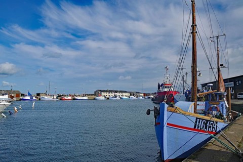 A harbour with fishing boats, blue sky and clouds in the background, Hirtshals, Jutland, Denmark,