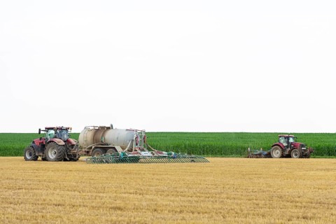 Farmers spread liquid manure on harvested grain field and plough it up, Swabian Alb,
