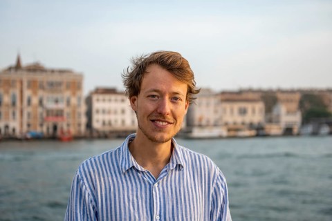 Young man in striped shirt, portrait, on the banks of the Grand Canal, looking into the camera,