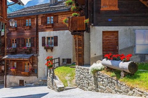 Old houses with flower boxes in front of windows and balconies, historic village centre, Grimentz,
