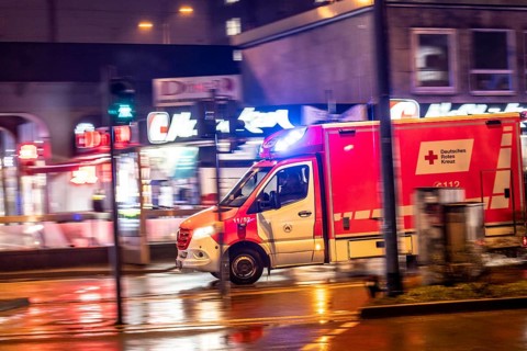 Ambulance on alarm, DRK, Essen fire brigade, rainy weather, city centre, evening, Essen, North