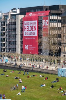 A construction company has hung a large poster on a building facade on the Rhine promenade,