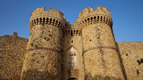 Fortress with impressive battlements and massive Tor tor under a clear blue sky, sea gate, harbour