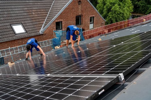 Installation of solar modules on the roof of a barn on a farm, over 240 photovoltaic modules are