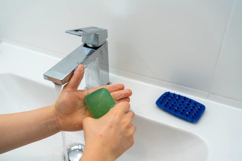 Domestic hygiene, washing hands, with a bar of soap, boy 9 years old