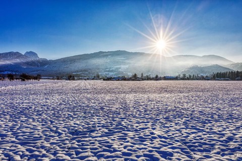 Snowy winter landscape in the morning sunshine with mountain views, Bad Feilnbach