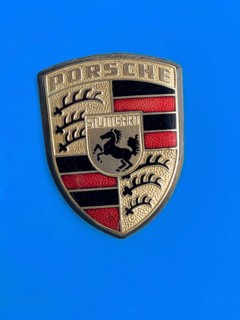 Historic old Porsche crest logo on blue painted bonnet of vintage classic car Porsche 911,