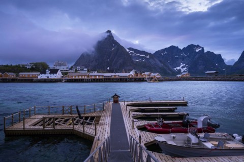 View of Sakrisoy with its typical yellow or ochre-coloured wooden houses on wooden stilts (rorbuer)