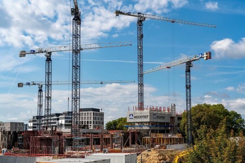 Construction cranes on two large construction sites, construction of office buildings in