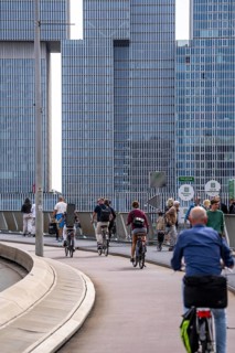 Cyclist on the cycle path of the Erasmus Bridge over the Nieuwe Maas, skyline of the skyscrapers on