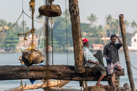 Fishermen resting, heavy stones attached to ropes, Chinese fishing nets, sunset, Arabian Sea coast,