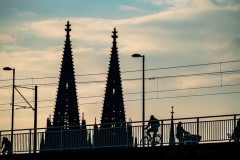 Cycling in the city, cyclist on the Deutzer Bridge in Cologne, Cologne Cathedral, cycle path, North