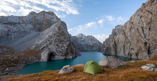 Wild camping, camping in the wilderness with a tent in front of mountain lake Kol Suu, Sary Beles