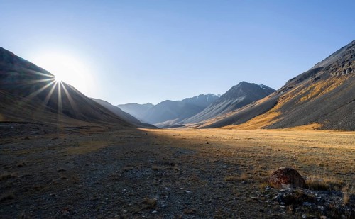 Mountain valley at sunrise, sun star, barren landscape, Burkhan valley, Tien Shan, Issyk Kul