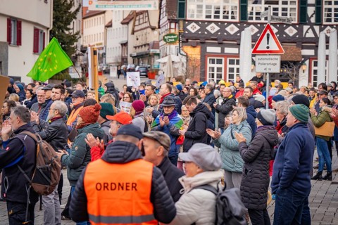 Demonstrators with banners in front of half-timbered houses, Assembly with police and respect sign,